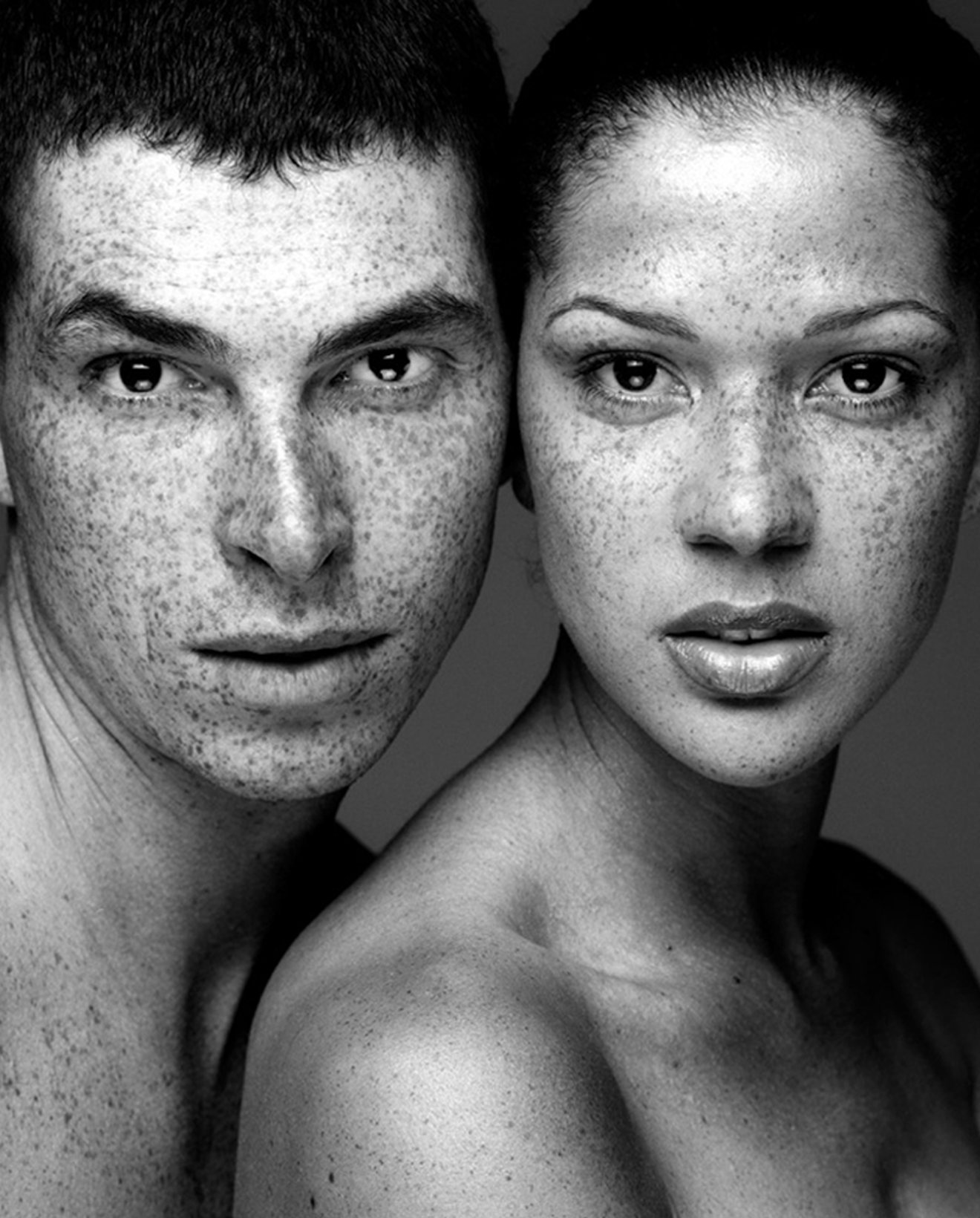 Black and white portrait of a freckled man and woman, cheek to cheek, by Karim Ramzi